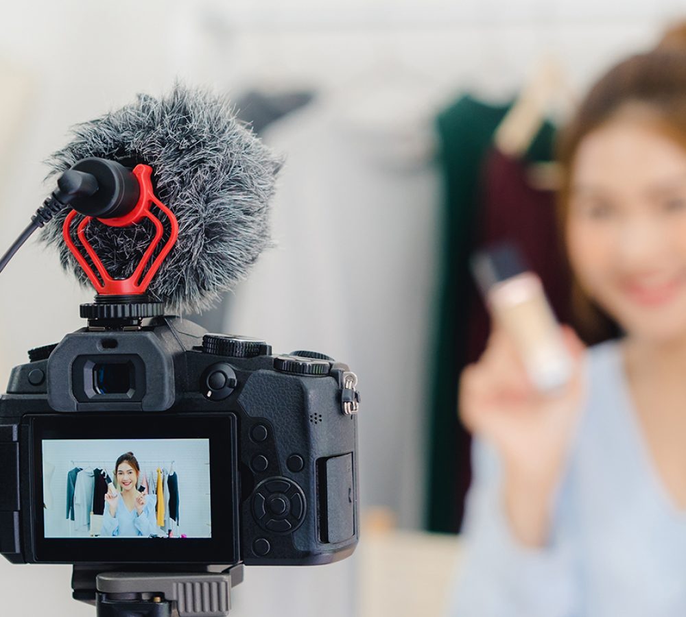 Beauty blogger present beauty cosmetics sitting recording video camera. Beautiful woman use powder while review make up tutorial broadcast live video to social network. Panoramic banner background.